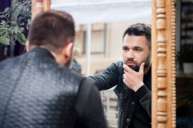 genç adam kendisi de aynaya bakar.