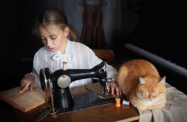Eski bir dikiş makinesinin yanında küçük bir kız ve bir kedi portresi..