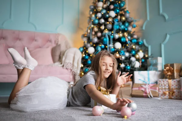 スタジオのクリスマスツリーの近くの女の子。休日の概念。子供の肖像10代. — ストック写真