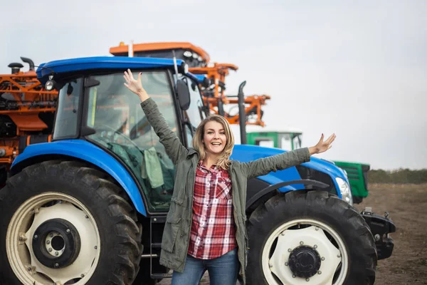 Jovem com emoções positivas perto do tractor. O conceito de sucesso na agricultura . — Fotografia de Stock