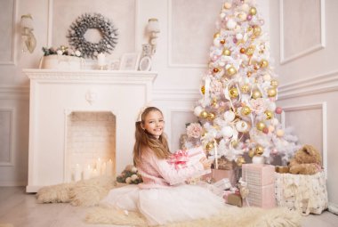 Elinde Noel hediyesiyle okul çağındaki küçük bir kız..