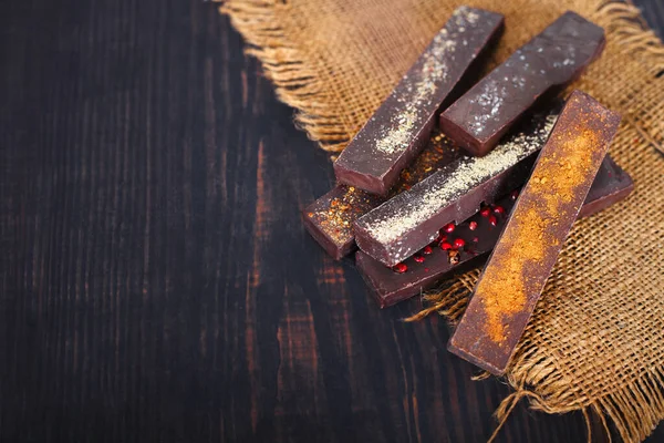 Cioccolato con spezie su uno sfondo di legno . — Foto Stock