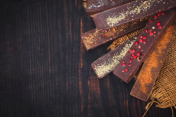 Cioccolato con spezie su uno sfondo di legno . — Foto Stock