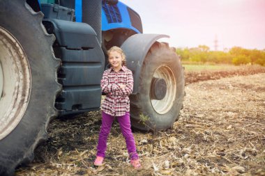 Tarladaki modern traktörün yanında tatlı bir kız..