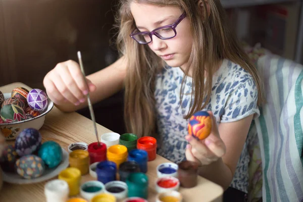 Nastolatka dziewczyna maluje wielkanocne jaja. — Zdjęcie stockowe