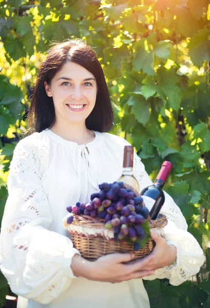 Junge Frau Mit Einem Korb Voller Trauben Und Flaschen Wein — Stockfoto