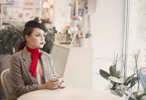 Portret van een jonge mooie vrouw in vintage stijl in een café. — Stockfoto