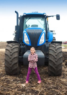 Tarladaki modern traktörün yanında tatlı bir kız..