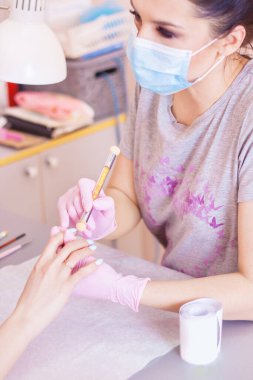 Manikürcü güzellik salonunda manikür yapıyor. Yakın plan..