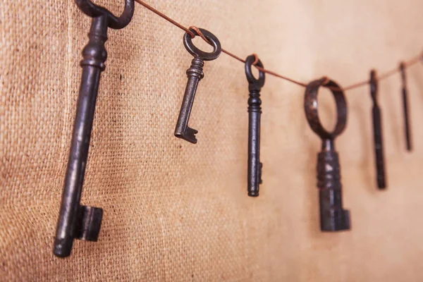 Flera gamla rostiga nycklar på en burlap bakgrund. Retro och vintage, steampunk. — Stockfoto