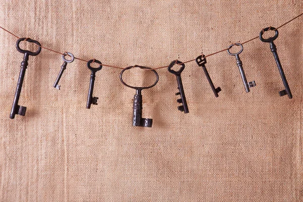 Flera gamla rostiga nycklar på en burlap bakgrund. Retro och vintage, steampunk. — Stockfoto