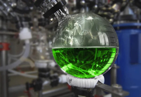 Tillverkning av läkemedel till en drog fabrik. grön vätska i en kolv — Stockfoto