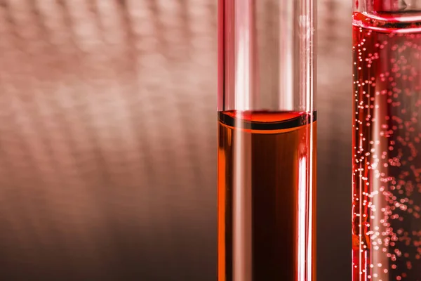 Posión líquida roja en tubo de vidrio sobre fondo abstracto — Foto de Stock