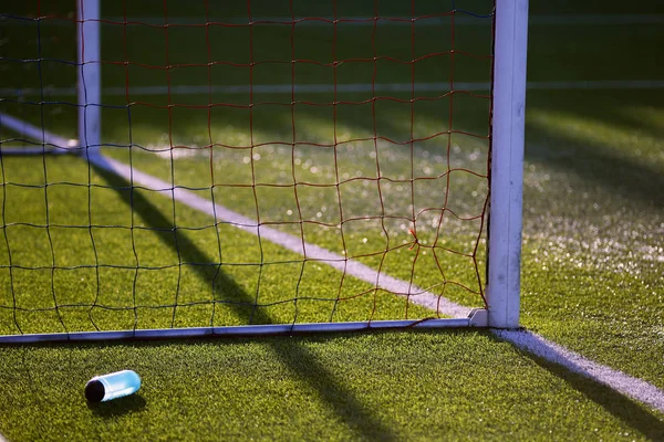 Botol dengan air dekat gerbang sepak bola di lapangan rumput buatan — Stok Foto