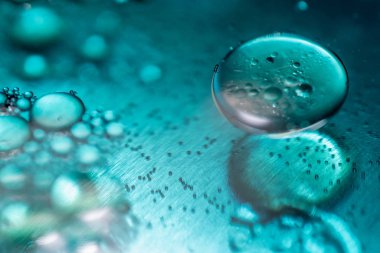 Renkli yağ damlaları ve bir metal dişli motor yüzeye kabarcıklar. Portre fotoğraf.