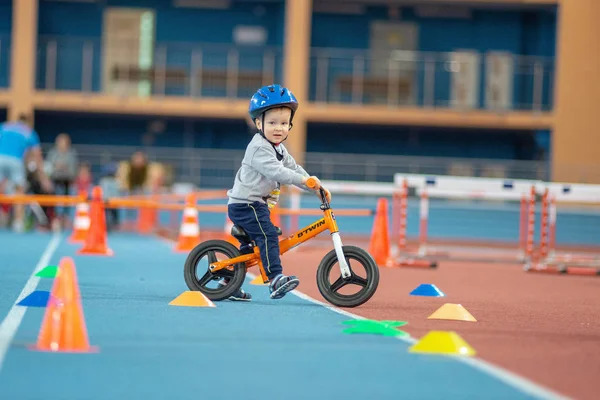 Minsk, Beyaz Rusya - 4 Şubat: Childs kask içinde denge Bisiklet ve çalışma Bisiklet Minsk, Beyaz Rusya 4 Şubat 2018 anne ile açık eğitim sırasında binmek.