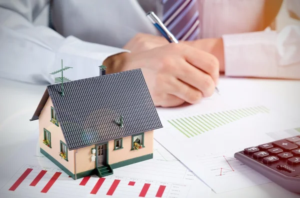 Podnikatel spočítat náklady na výstavbu a údržbu domů — Stock fotografie