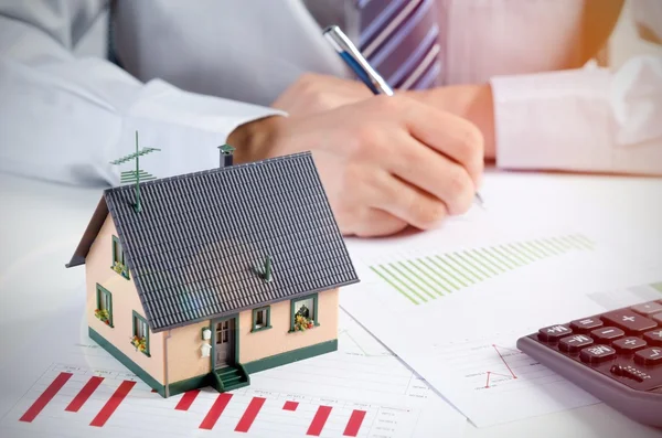 Businessman calculate the cost of building and maintaining home — Stock Photo, Image