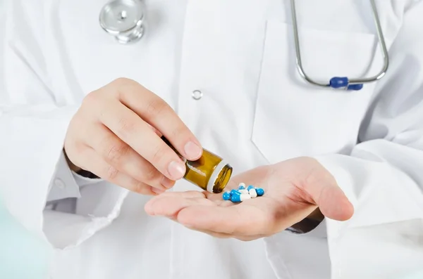 Arzt schüttet Tabletten auf seine Hand. medizinisches Konzept im Krankenhaus. — Stockfoto