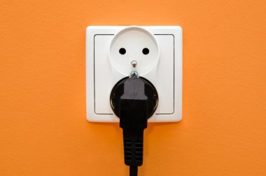 Turuncu duvar Elektrik yuvası. Elektrik faturası yarar maliyet artış