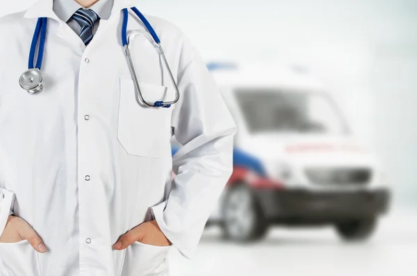 Arts in het ziekenhuis met de ambulance op achtergrond — Stockfoto