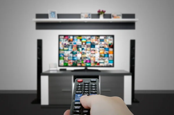 Guardare la televisione nella moderna sala TV. Telecomando a mano — Foto Stock