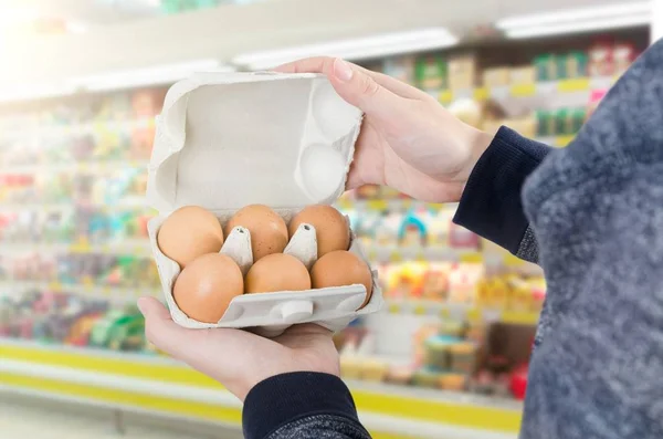 Uomo che tiene la scatola delle uova nel supermercato — Foto Stock