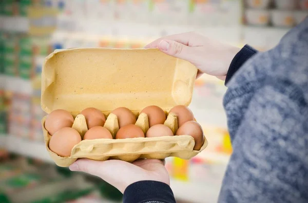 Yumurta kutusu süpermarkette tutan adam — Stok fotoğraf
