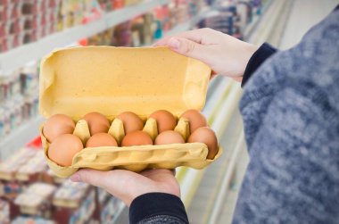 Yumurta kutusu süpermarkette tutan adam