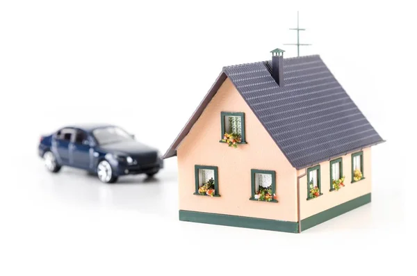 Huis miniatuur en auto model op achtergrond — Stockfoto