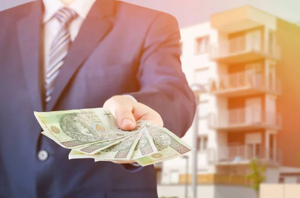 Polish businessman holds money. The loan on the house
