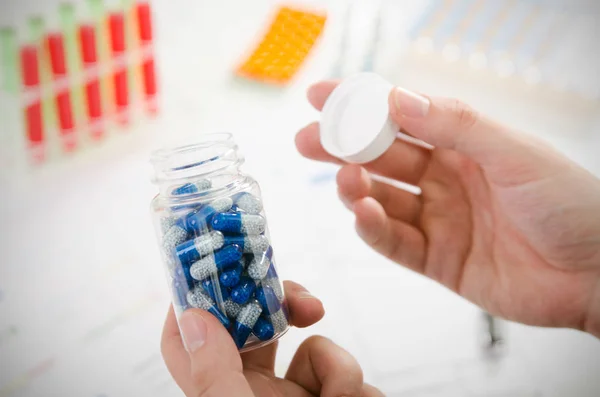 Person opens a bottle of drugs — Stock Photo, Image