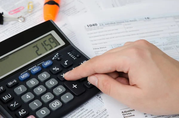 Man calculates income tax — Stock Photo, Image