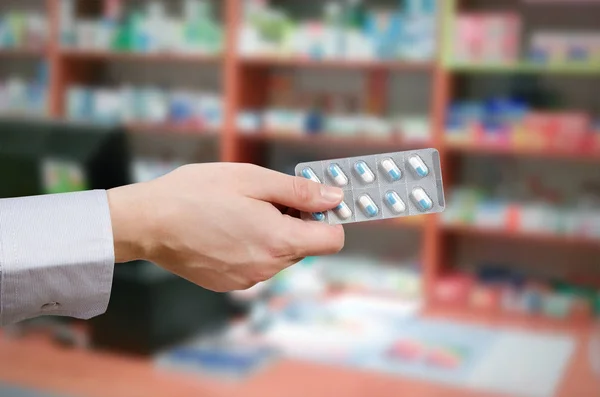 Pharmacien tenant des comprimés dans les mains — Photo