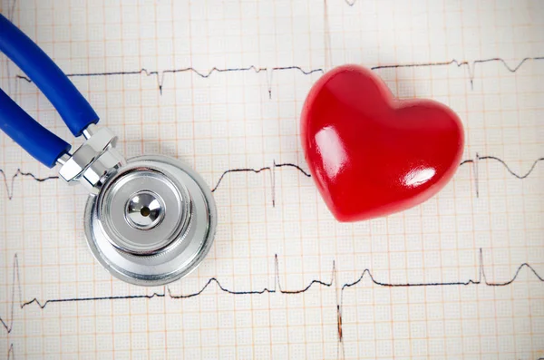 Стетоскоп и модель сердца на кардиограмме — стоковое фото