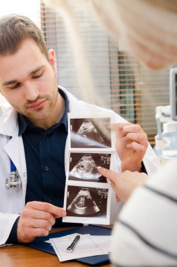 Doktor gösteren bebek ultrason görüntüsü hamile kadına