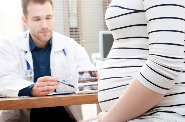 Médico mostrando imagem de ultra-som do bebê para mulher grávida — Fotografia de Stock