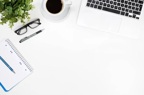 Table de bureau avec ordinateur portable, tasse à café et fournitures vue sur le dessus — Photo