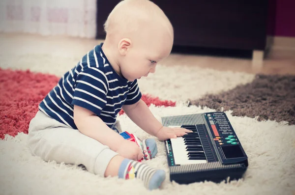 Little baby boy plays on keyboard toy — Stock Photo, Image