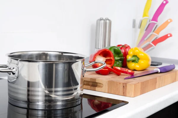 Panela e legumes na cozinha moderna com fogão de indução — Fotografia de Stock