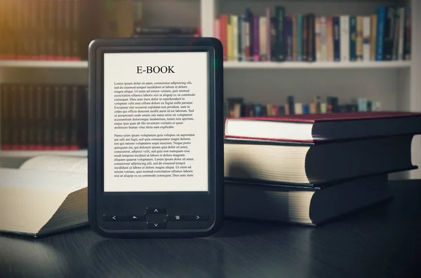 E-book reader device on desk in library — Stock Photo, Image