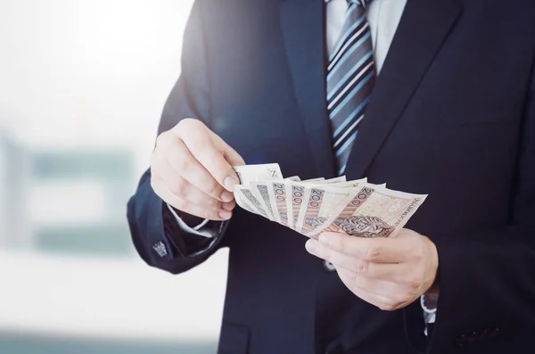 Bereik van de Poolse bankbiljetten in zakenman hand — Stockfoto