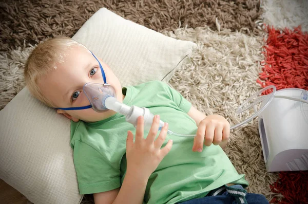 Pojke att göra inandning med nebulisatorn hemma — Stockfoto