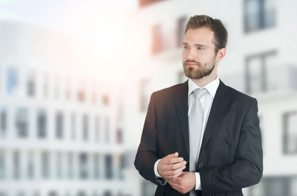 Ung affärsman i kostym med staden i bakgrunden — Stockfoto