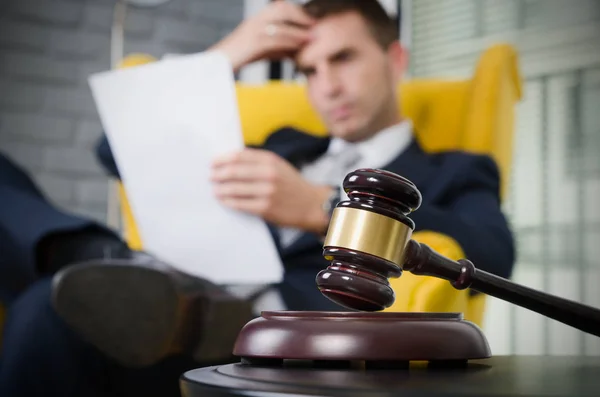 Wooden gavel, working lawyer in background — Stock Photo, Image