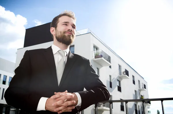 Uomo d'affari rilassato in piedi sul balcone del suo appartamento — Foto Stock