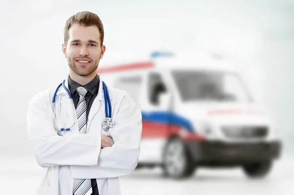 Doctor in hospital with ambulance in background — Stock Photo, Image