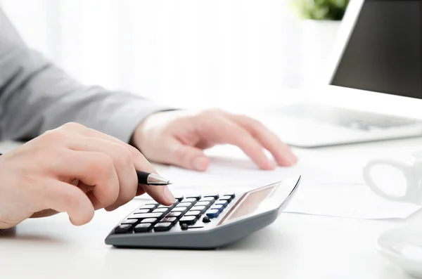 Accountant calculates tax. Working in the office with calculator — Stock Photo, Image