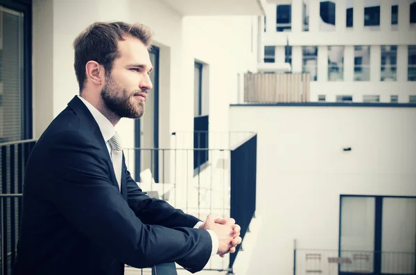 Yakışıklı işadamı kenti bir balkon keyfi — Stok fotoğraf