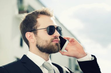 Yakışıklı işadamı telefon şehir üzerinde açık söz